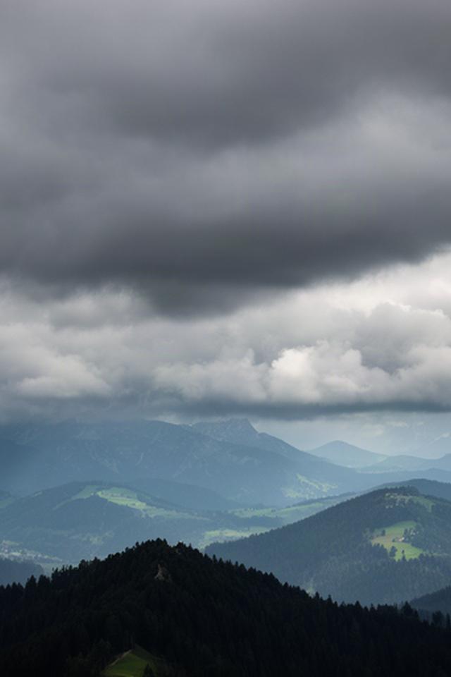 Dichte Wolken ziehen über einen bewaldeten Bergrücken in der Steiermark