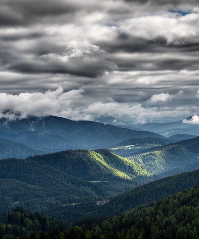 Wolken über dem weststeirischen Bergland, aufgenommen mit Blick auf bewaldete Hänge